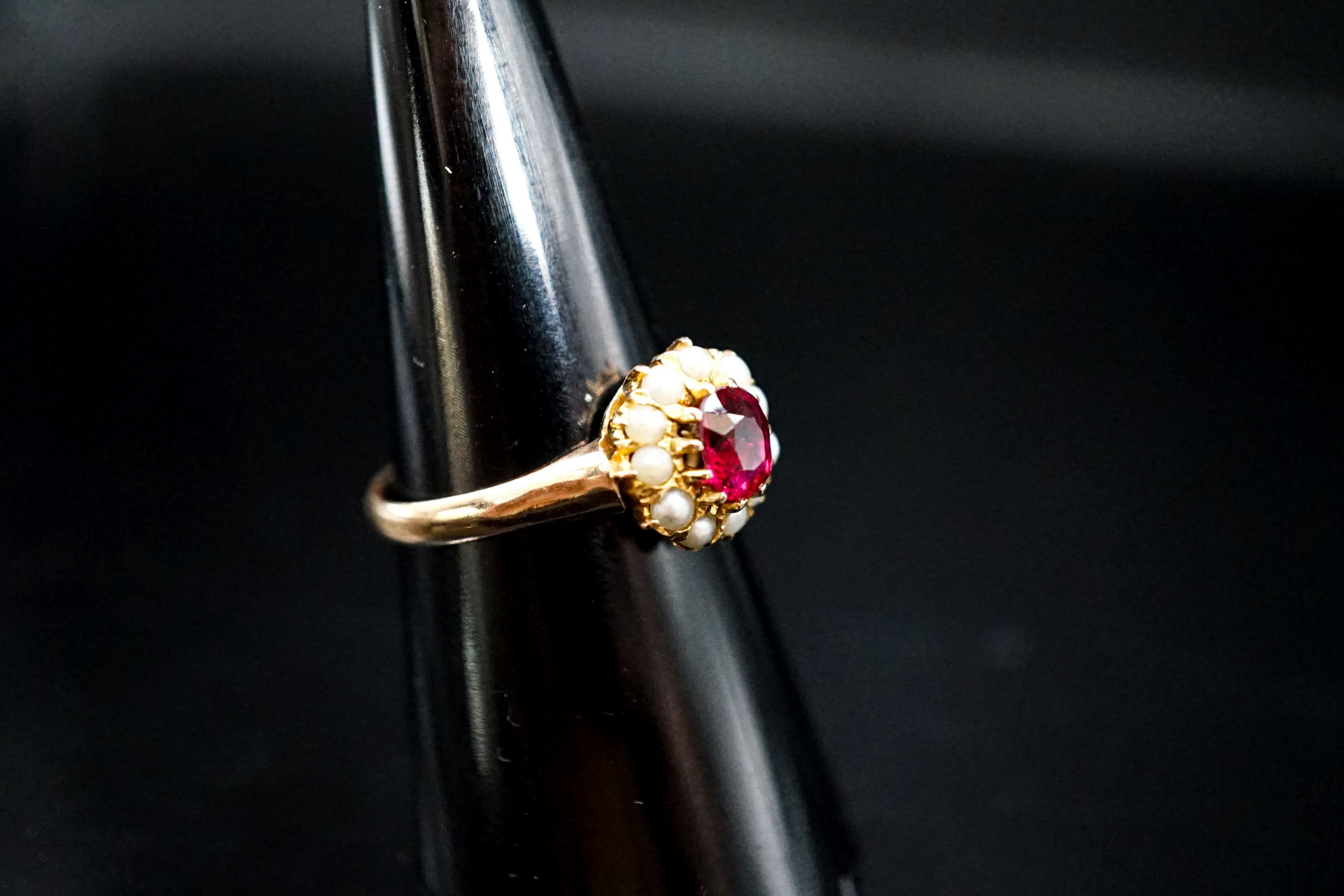 A yellow metal, ruby and seed pearl circular cluster ring, size N, gross weight 3.2 grams.